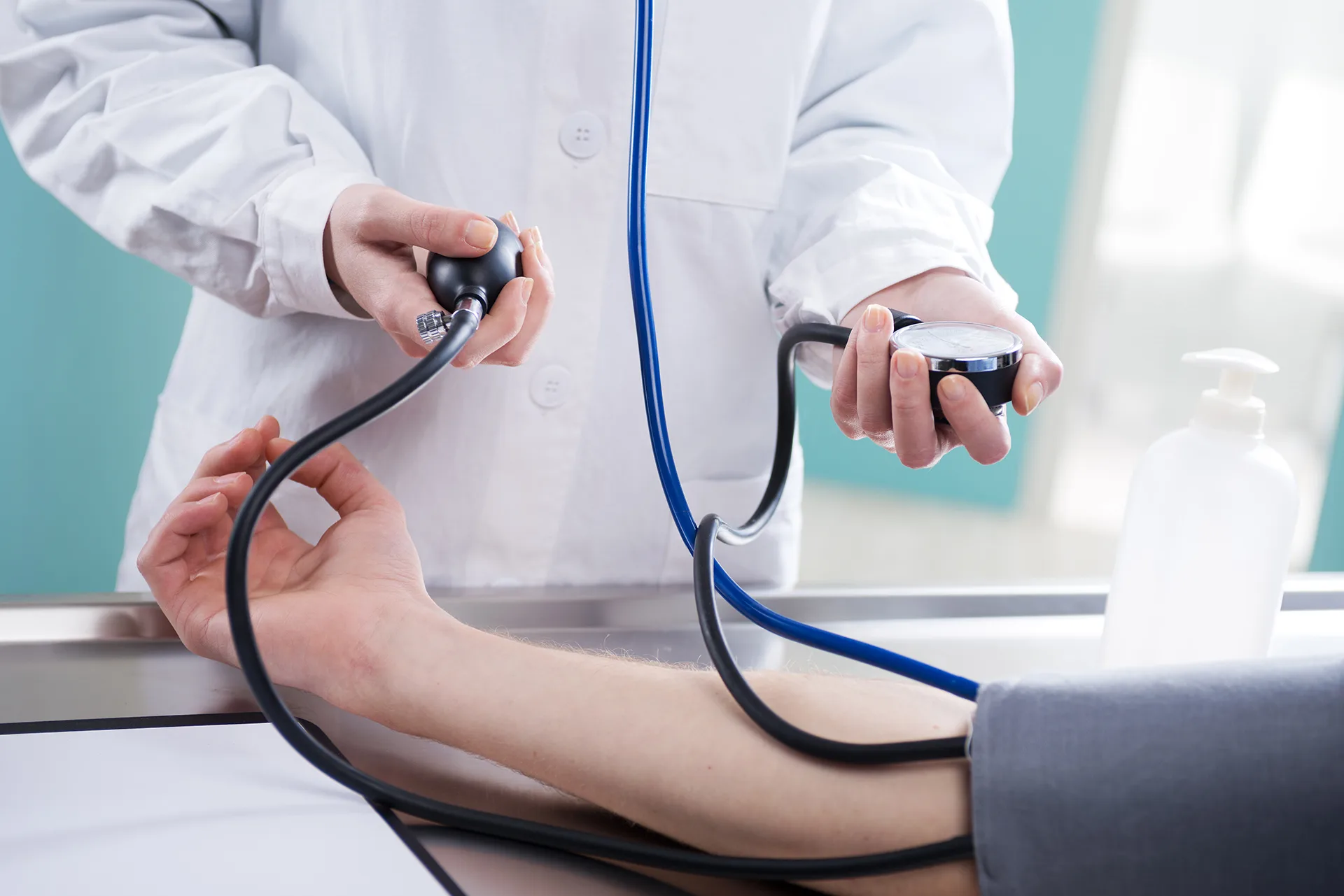 A clinician taking a patient's blood pressure with a manual cuff and gauge